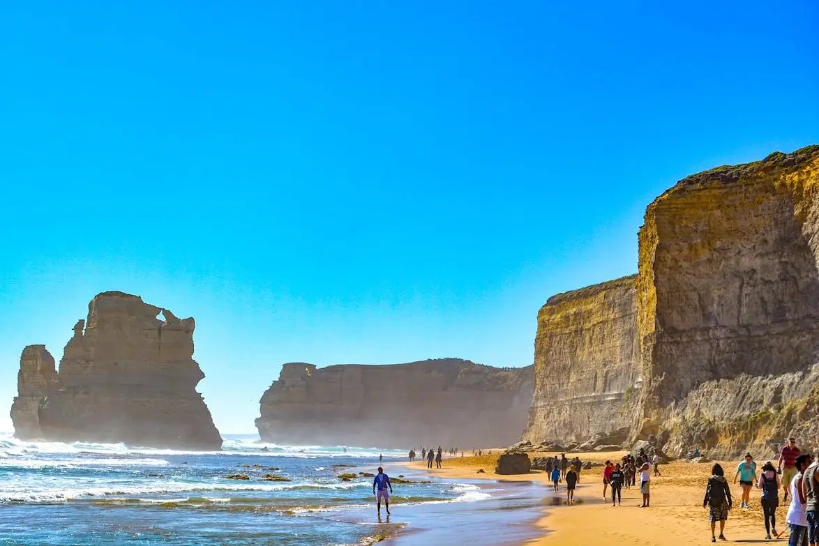 Twelve Apostles limestone pillars standing in blue ocean waters along rugged coastline