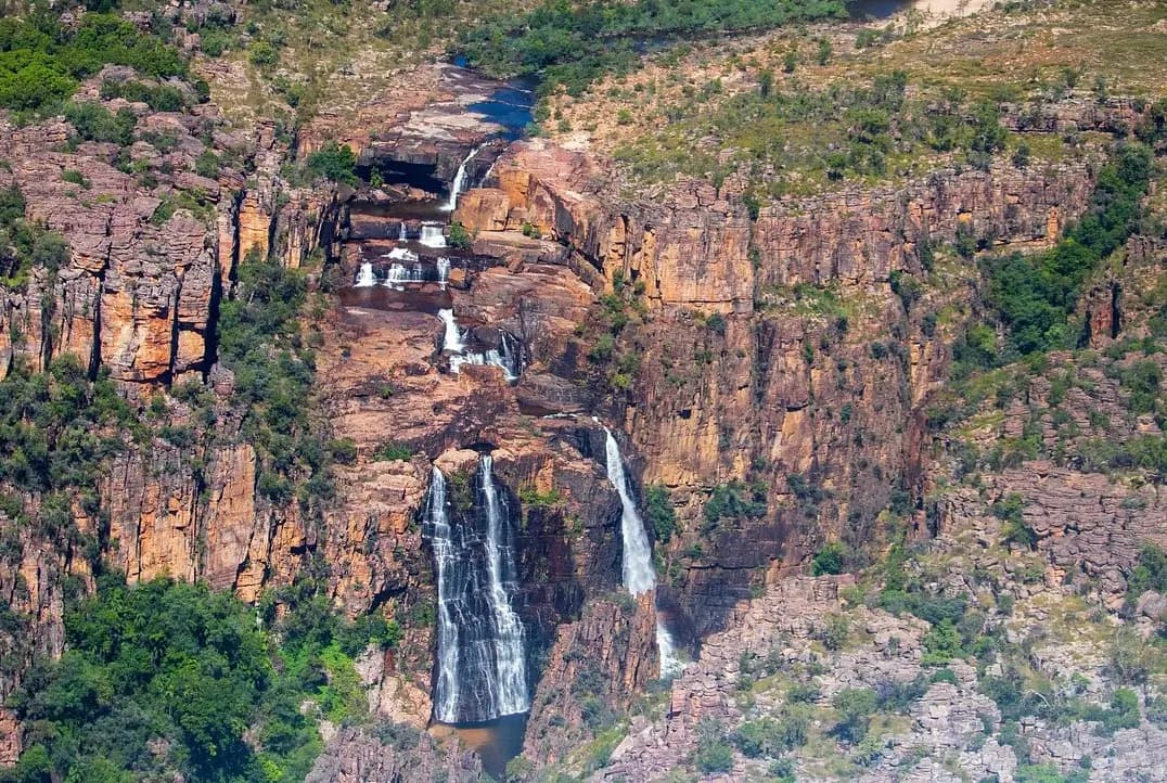 Ancient Aboriginal rock art paintings on red rock wall in natural cave setting