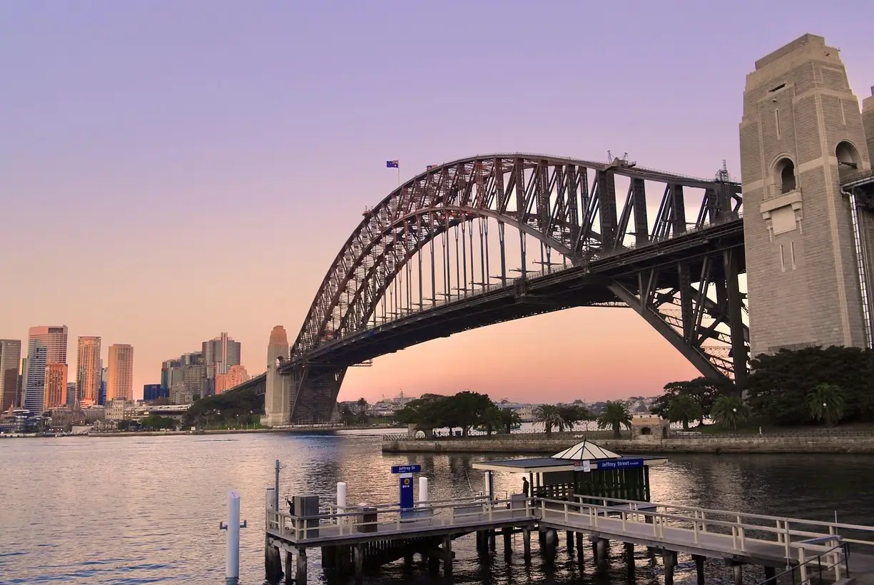 Sydney Harbour Bridge spanning blue waters with city skyline in background