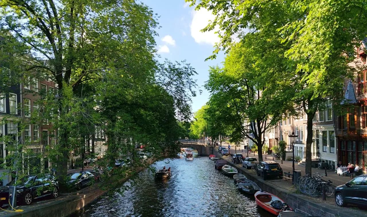 Amsterdam canal with boats and traditional houses at sunset