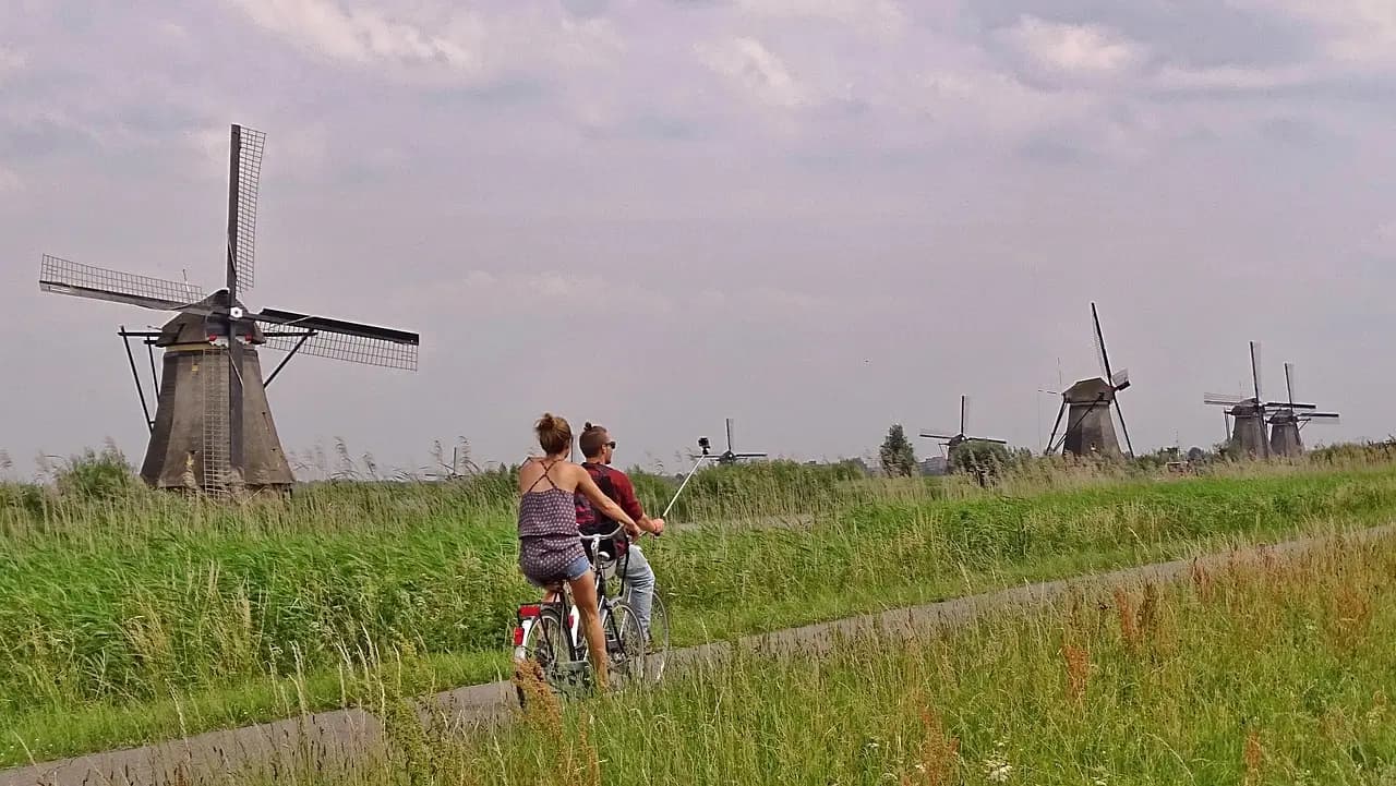 Row of historic windmills reflected in the water at Kinderdijk