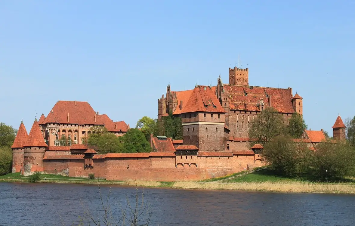 Aerial view of Malbork Castle with red brick walls and towers