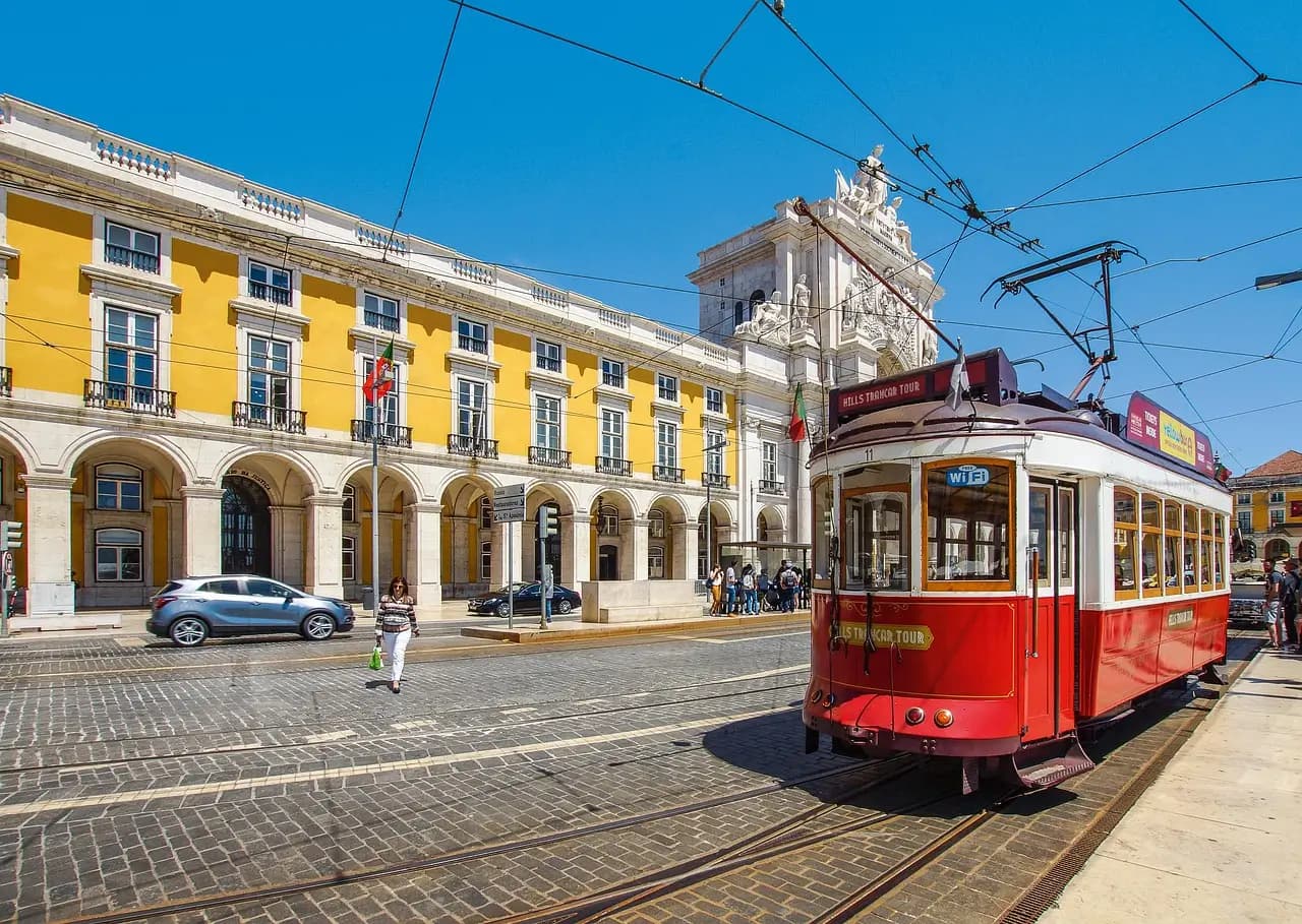 Yellow tram passing through colorful streets of Lisbon