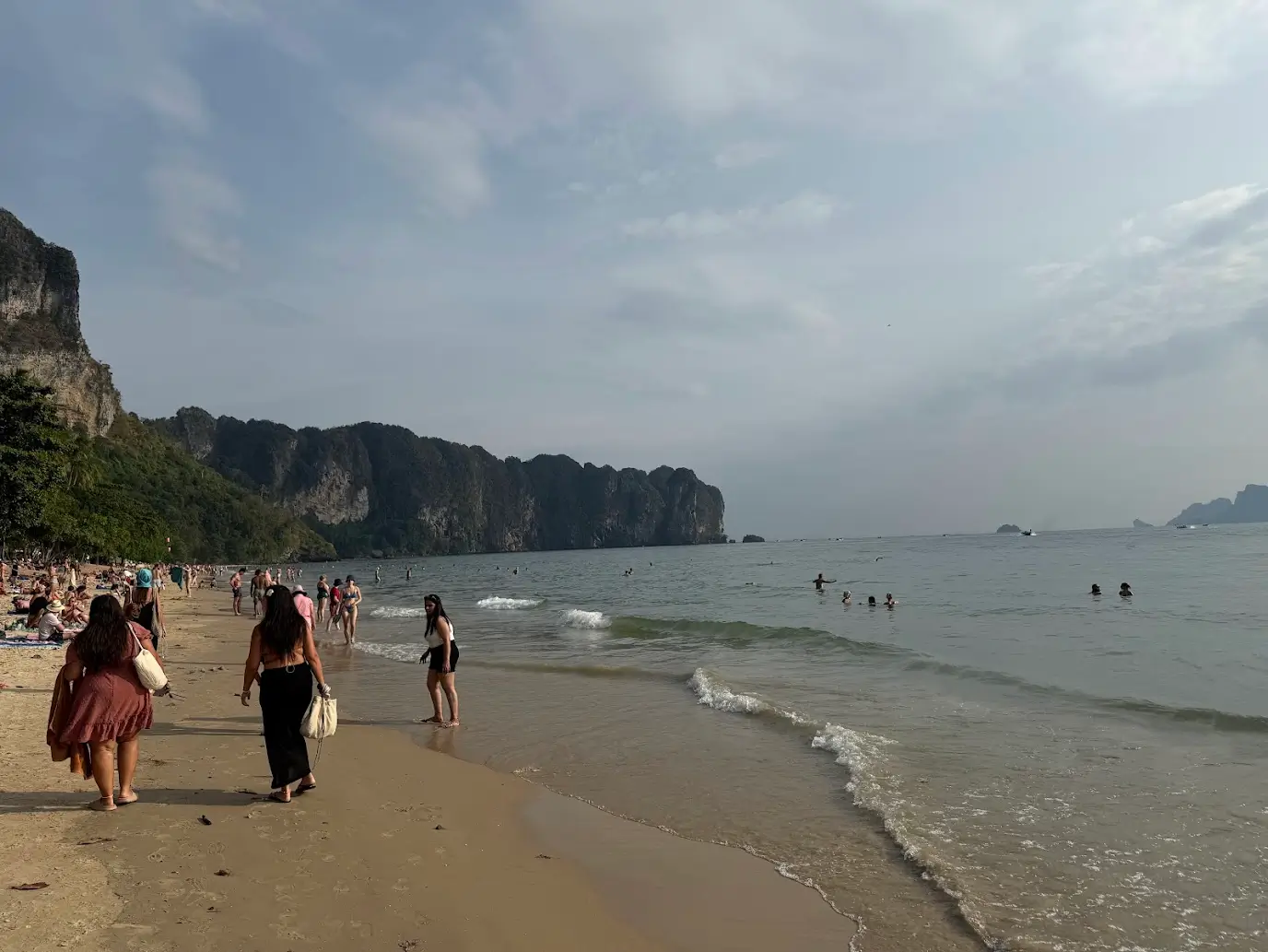 Golden sunset over Ao Nang Beach with limestone cliffs in the background