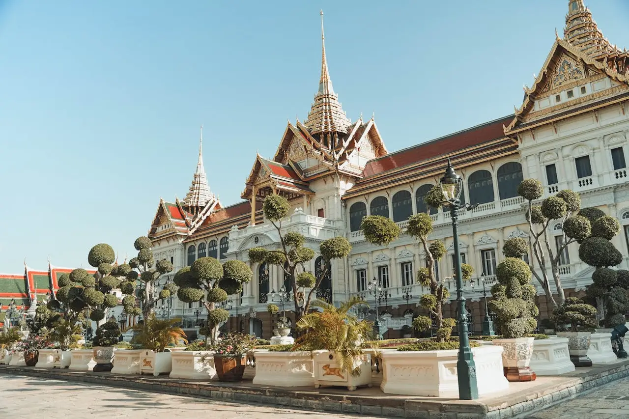Golden spires and ornate architecture of Bangkok Grand Palace with traditional Thai roofing