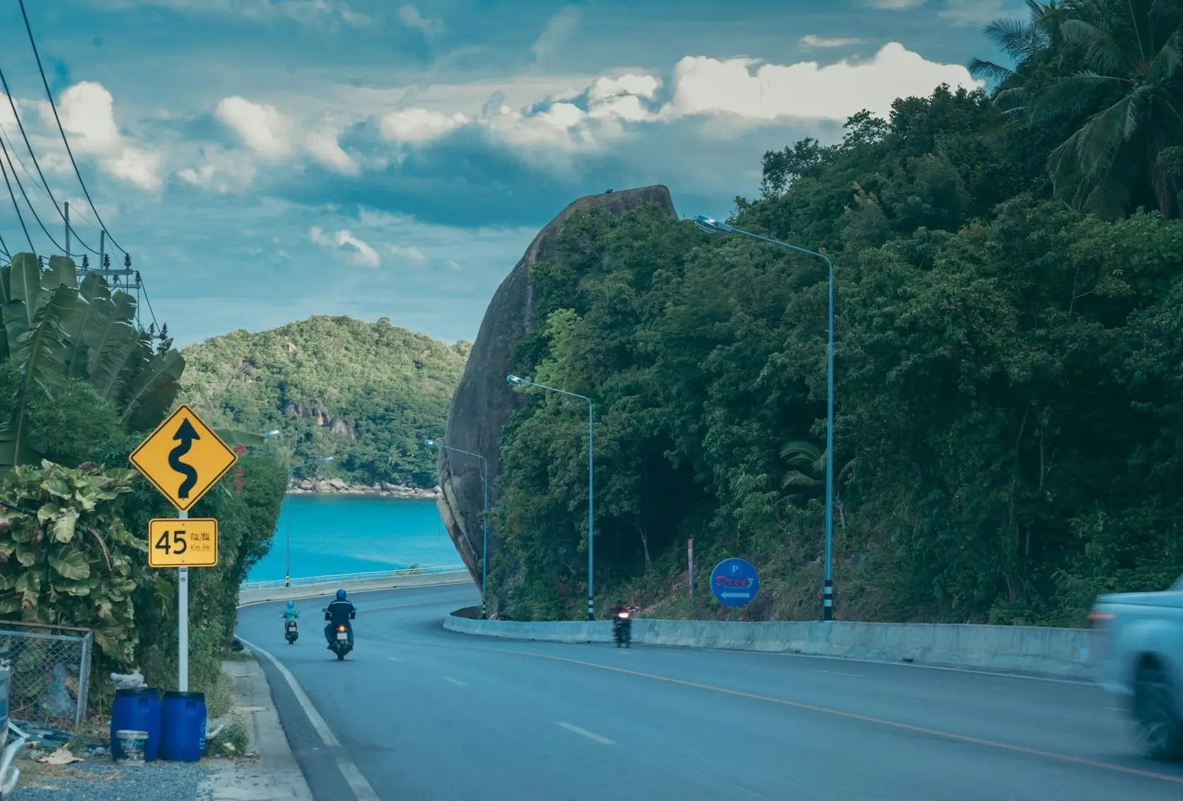 Tropical beach with coconut palms, luxury resort, and clear blue water with traditional longtail boat